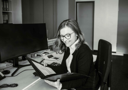 Profilbild von Isabella Hinz, die in eine Mappe blickt